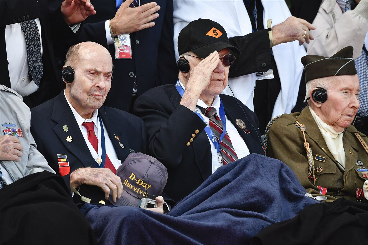 World War II veterans, including a D-Day survivor, render a salute during a remembrance ceremony.