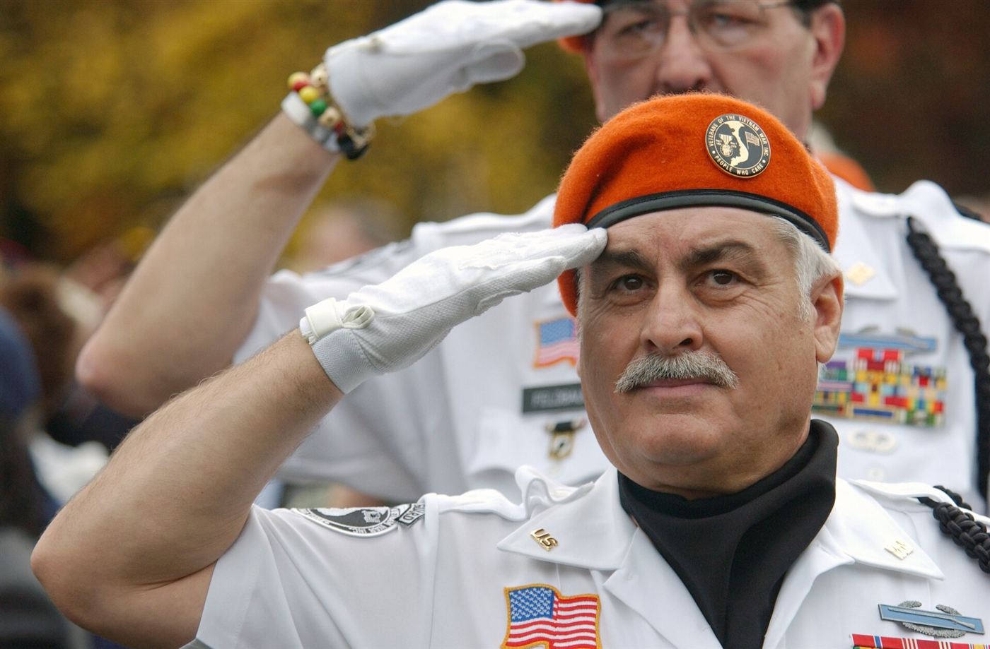 Two Vietnam veterans salute as the colors are retired.